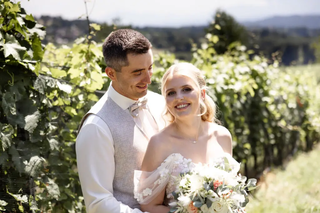 Hochzeit am TrippelGut am Maltschacher See – Brautpaar in den Weinbergen Brautpaar bei der Hochzeit am TrippelGut am Maltschacher See in den Weinbergen, Braut schaut in die Kamera