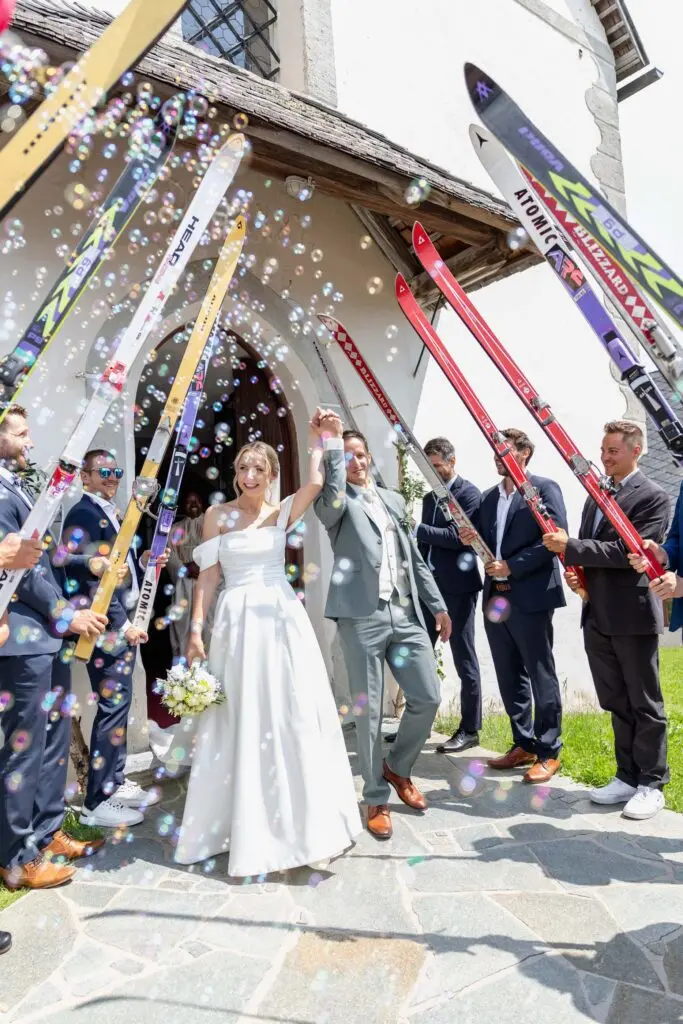Hochzeit in den Nockbergen – Spalier vor der Kirche Brautpaar verlässt die Kirche und wird von Gästen beim Spalierstehen empfangen