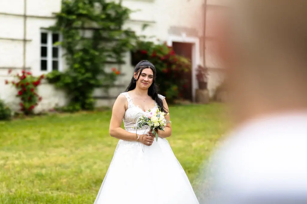 Braut im weißen Kleid im Drautal Braut im weißen Hochzeitskleid auf einer Wiese vor einem alten Gebäude im Drautal