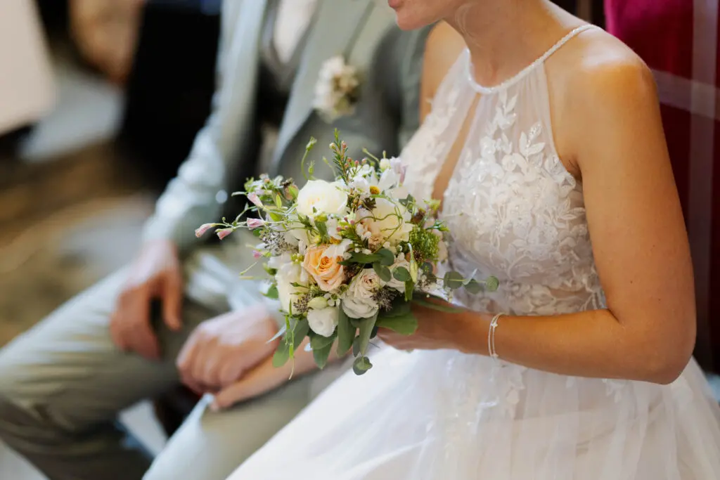 Hochzeit in Glanegg – Brautstrauß bei der kirchlichen Trauung Braut hält ihren Brautstrauß während der kirchlichen Trauung in der Kirche in Glanegg
